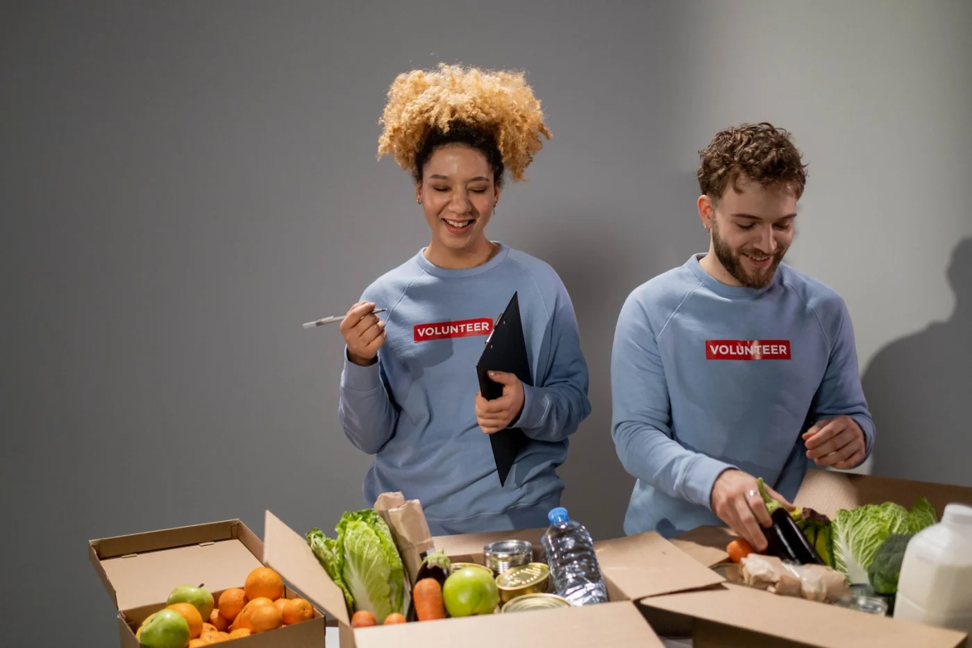 Two volunteers packing donated goods into boxes