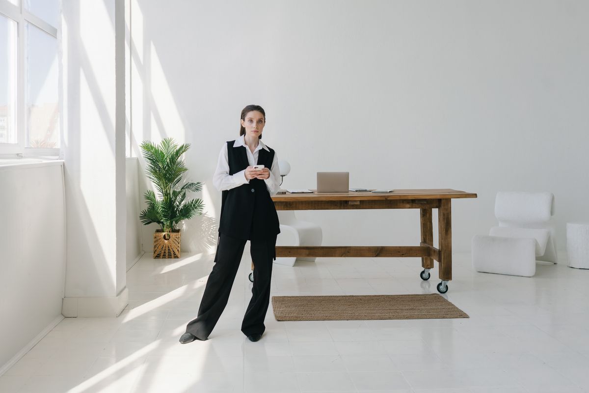 A professional using a smartphone in a bright workspace